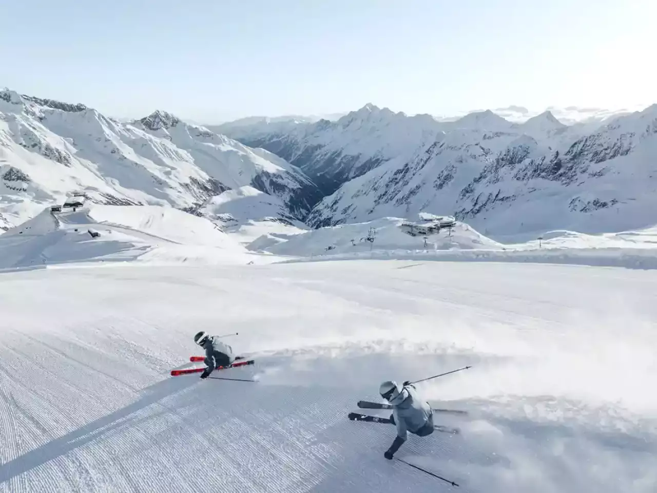 2 Skifahrer auf der Piste mit Bergpanorama