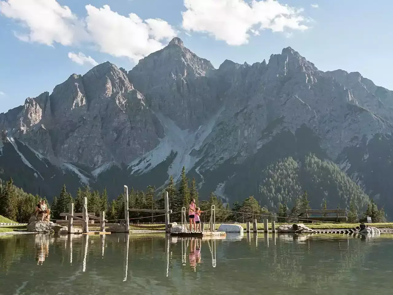 Kinder auf einem Floß mit Berge im Hintergrund