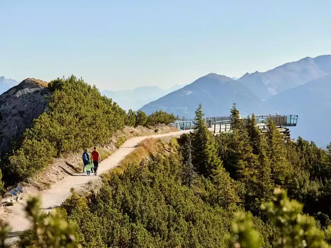 Menschen zu einer Aussichtsplattform und betrachten die Berge