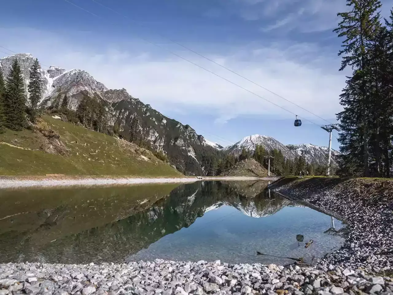 Bergsee mit Gondel im Hintergrund